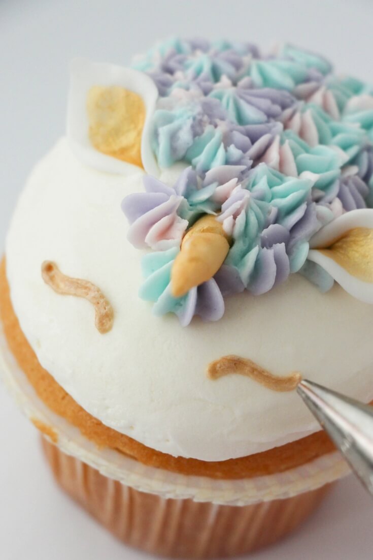 decorating a unicorn cupcake.