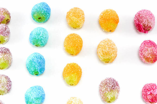 Vibrantly colored Rainbow Jello Frosted Grapes are as pretty as they are delicious! This party treat is sure to be a hit with both kids and grown-ups alike!