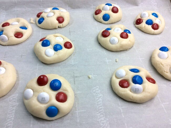 red white and blue M&M cookie dough on baking sheet