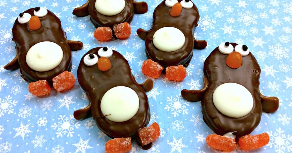 Adorable chocolate dipped Nutter Butter Penguin Cookies are just as fun to make as they are to eat! Easy kids holiday party dessert.