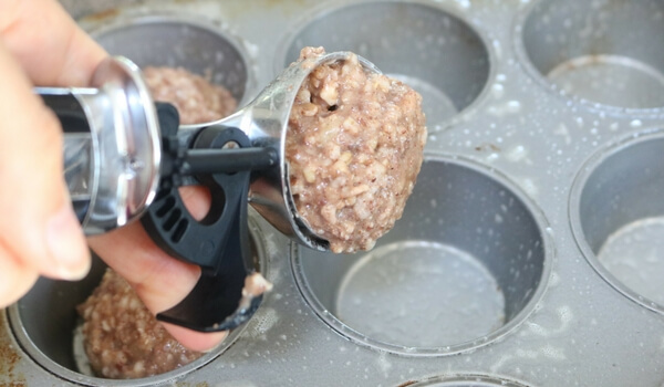 Scooping oatmeal into muffin tin