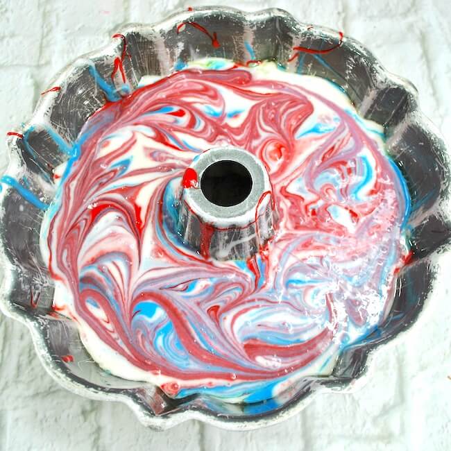 Red white and blue batter swirled in bundt cake pan