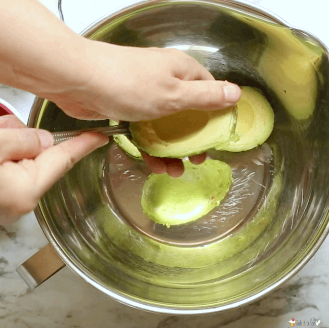 Scooping avocados into mixing bowl