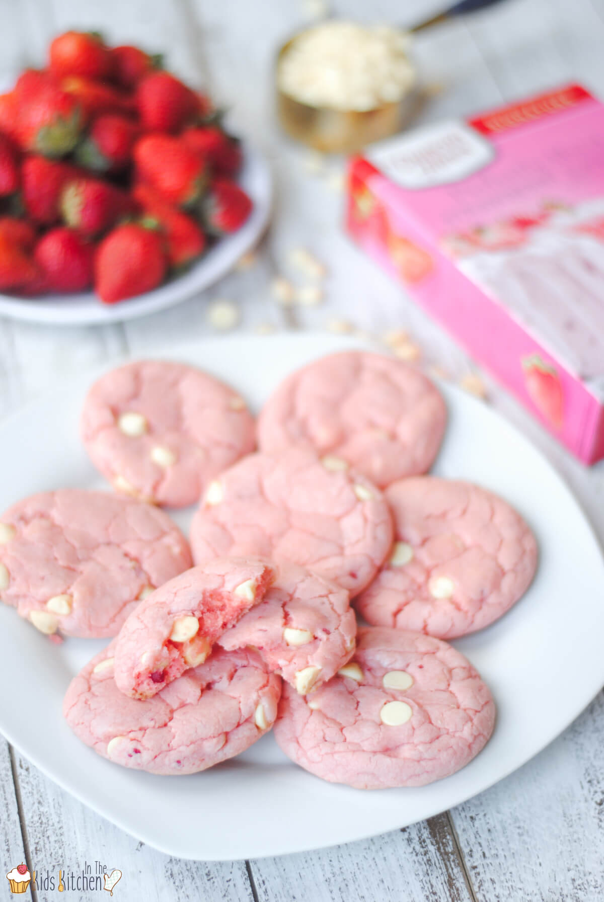 plate of strawberry cake mix cookies and a plate of strawberries
