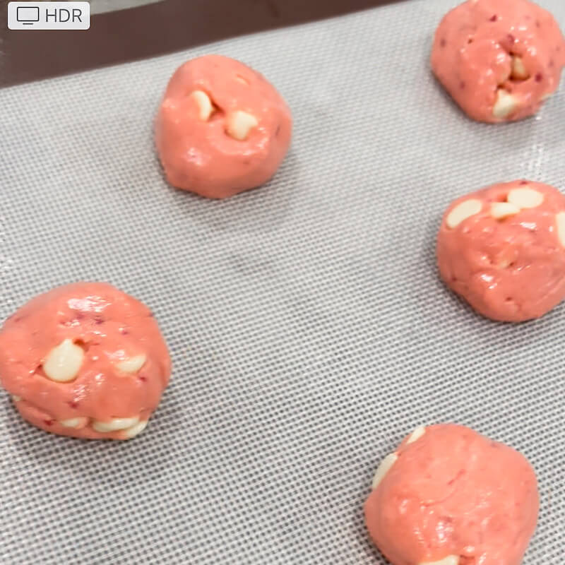 balls of strawberry cookie dough on baking sheet