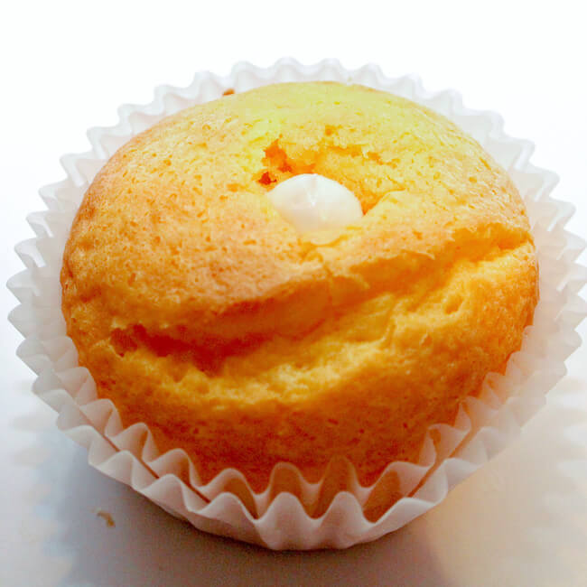 yellow cupcake with white frosting in the middle, no frosting on top