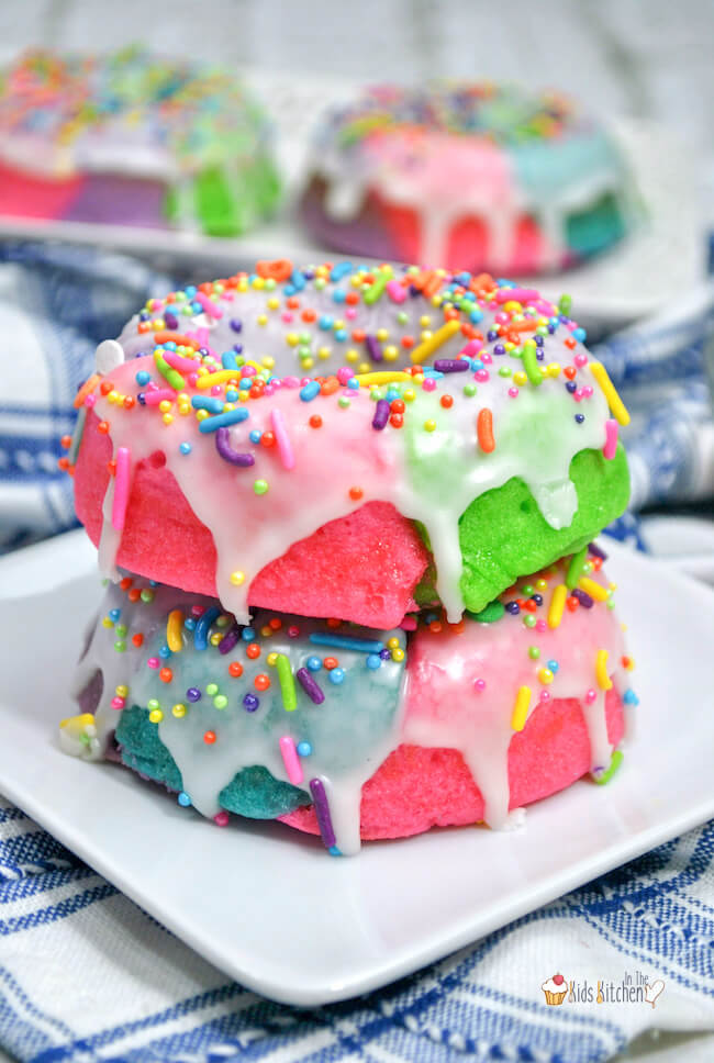 Kids will go wild for these rainbow swirled Unicorn Donuts! Easy baked donut recipe with sugar glaze - a guaranteed hit for any occasion!