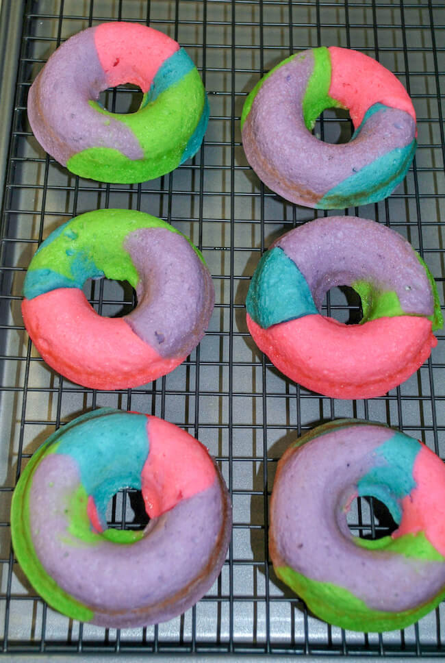 baked rainbow donuts on wire cooling rack