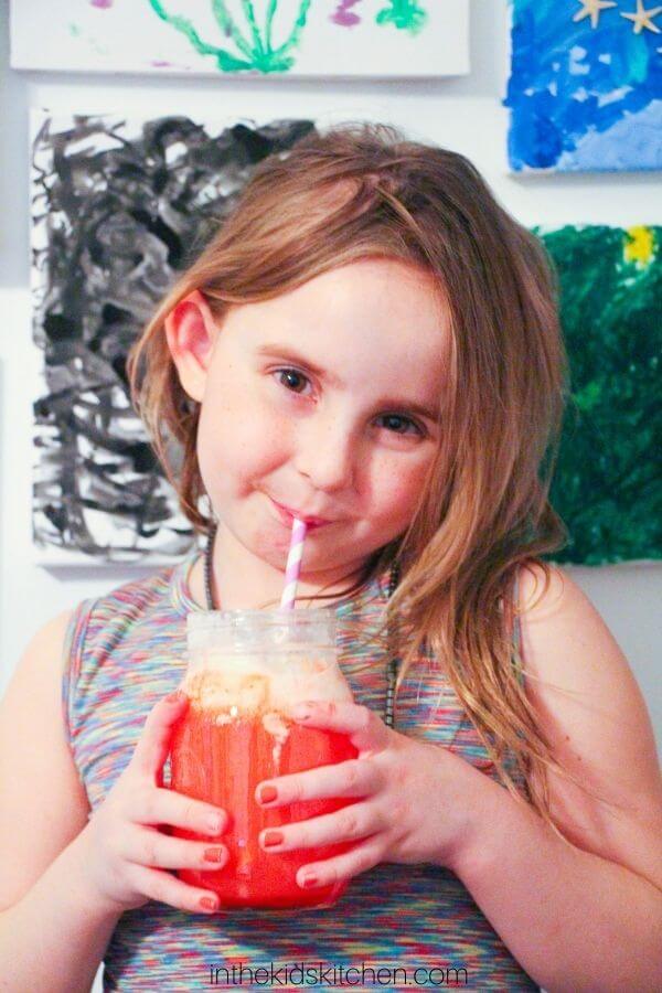little girl drinking a strawberry ice cream float