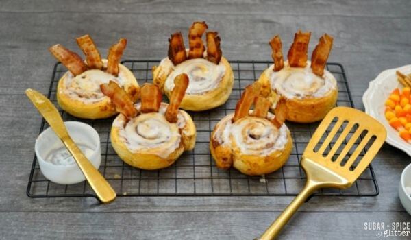 iced cinnamon rolls with bacon sticking out