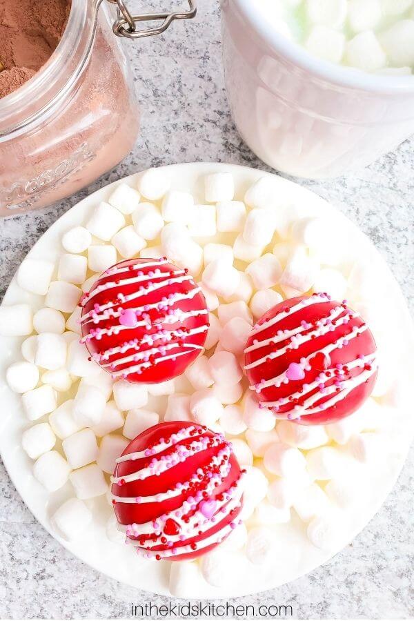 Valentine's Day hot chocolate bombs on a bed of marshmallows