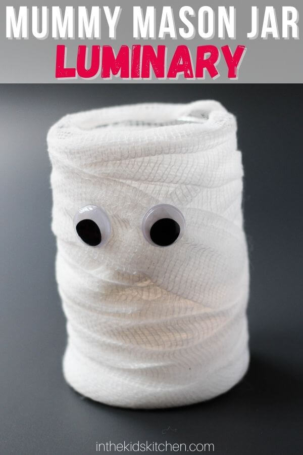 mason jar wrapped in gauze with google eyes; text overlay "Mummy Mason Jar Luminary"