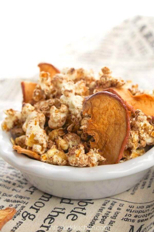 bowl of cinnamon coated popcorn with dried apples