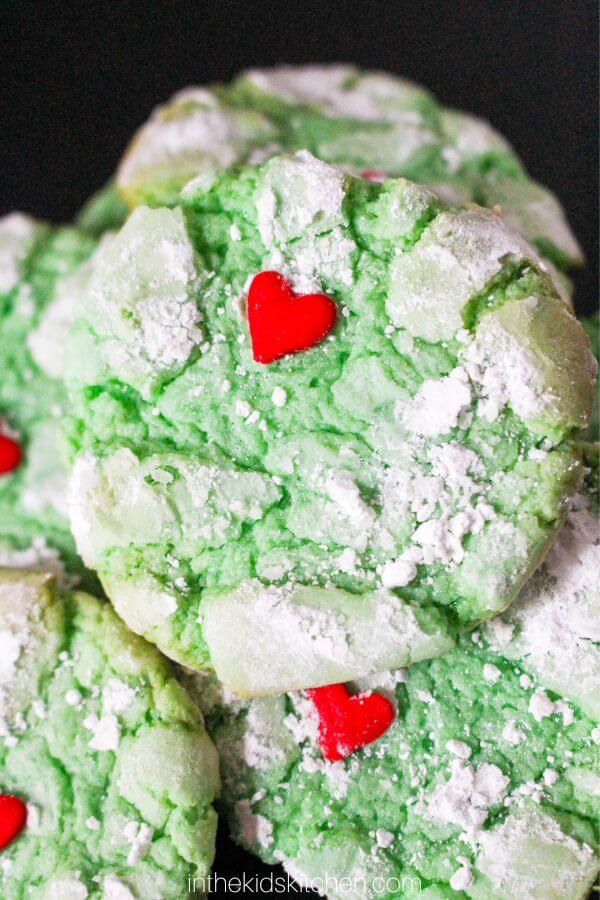 green crinkle cookies with a red heart sprinkle.