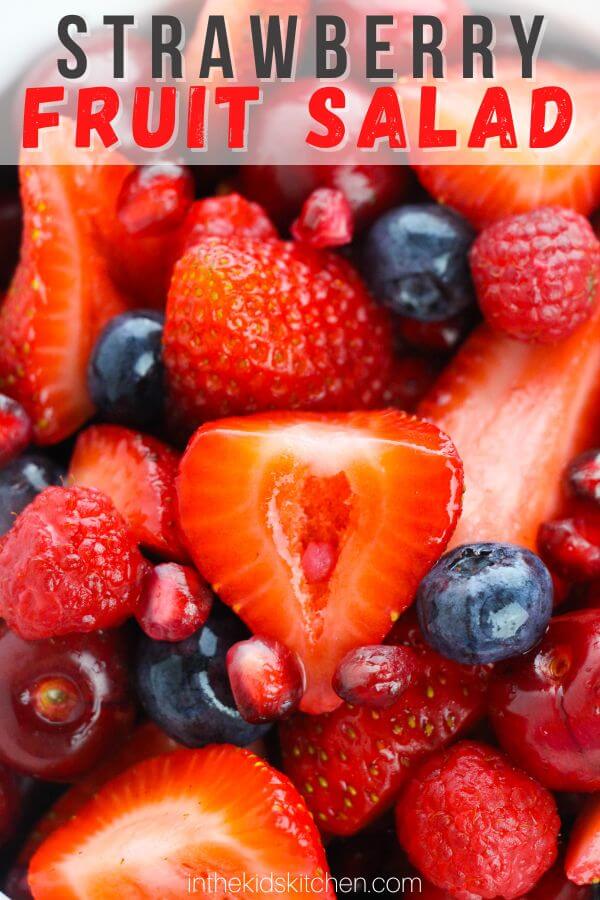 close up of berries in fruit dressing, text overlay "Strawberry Fruit Salad".