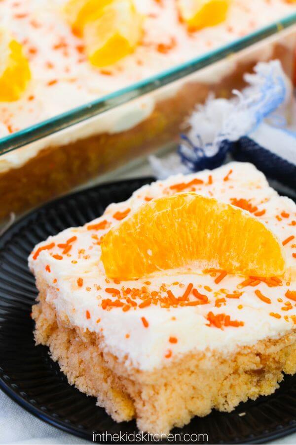 slice of orange creamsicle cake with white frosting