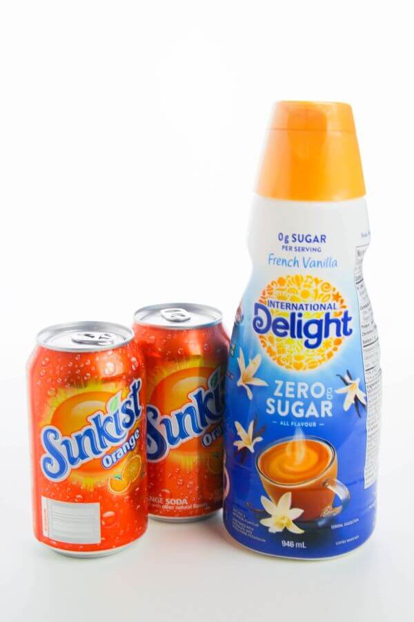 2 cans of orange soda and one bottle of coffee creamer.