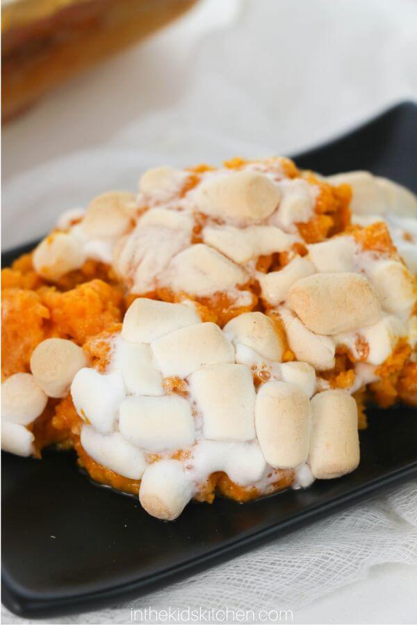 close up of a serving of sweet potato casserole, topped with melted marshmallows