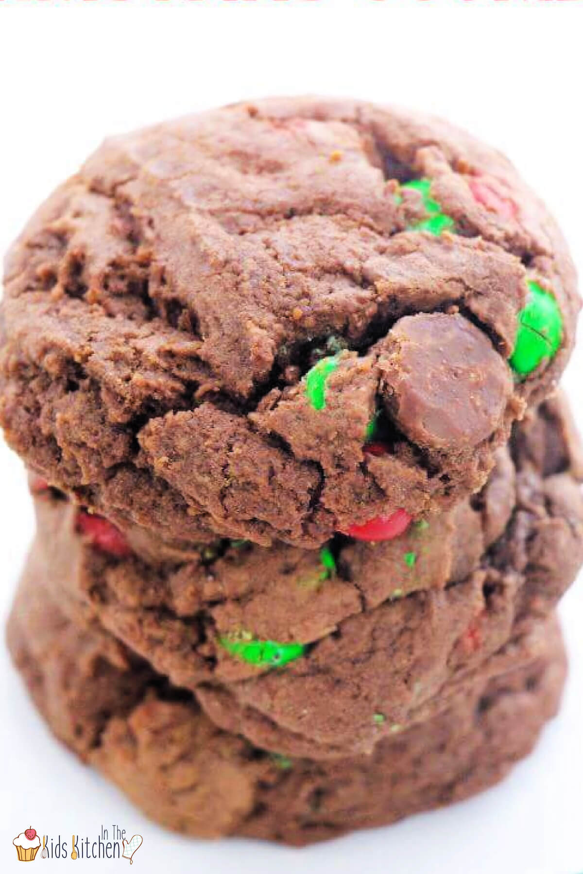 stack of three chocolate cookies filled with Christmas M&Ms.